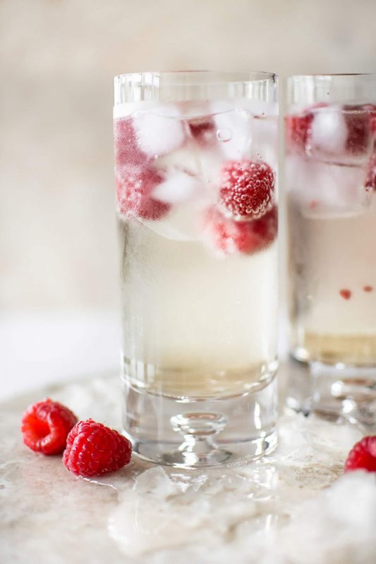 Two elderflower cocktails in glasses with berries