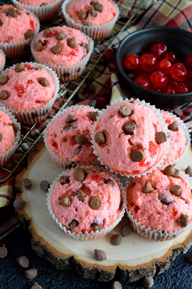 A pile of pink cherry chocoalte chip muffins on a plate