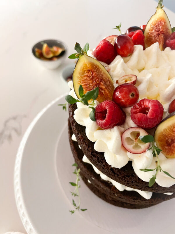 Chocolate cake with vanilla frosting, raspberries, figs.