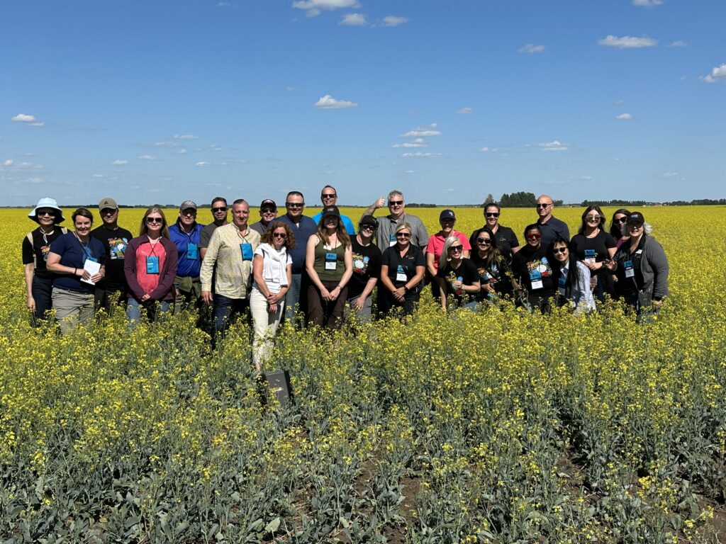 a tour group standing in a canola field
