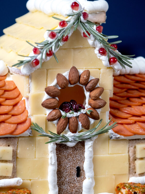 Charcuterie house with pepperoni, almonds and cheese.